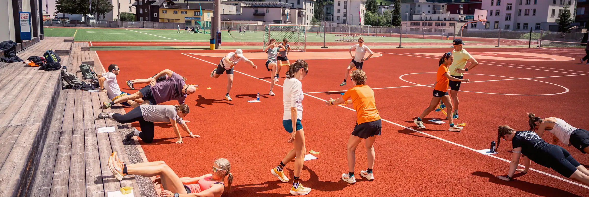 A training group warming up on the red running track in Davos.